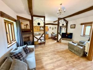 a living room with a couch and a tv at Very spacious rural 2 bed barn sleeps 5 in Usk