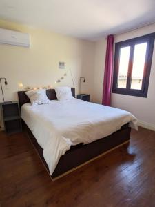 a bedroom with a large bed with white sheets at Au Marron in Seissan +37 photos