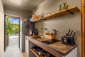 a kitchen with a counter with a sink and a refrigerator at Bali Suites - Ubud Suite in Willemstad