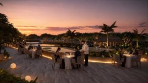 a group of people sitting at tables on a patio at Delta Open Air Resort in Porto Garibaldi