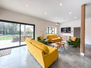 a living room with a yellow couch and green chairs at 4 Bed in Acton oc-k40259 in Waldingfield