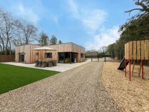 a house with a playground in front of it at 4 Bed in Acton oc-k40259 in Waldingfield