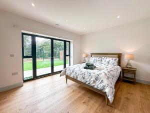 a bedroom with a bed and a large window at 4 Bed in Acton oc-k40259 in Waldingfield
