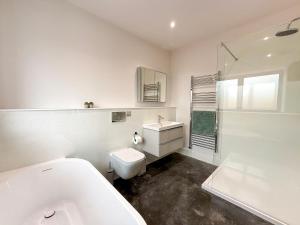 a bathroom with a tub and a toilet and a sink at 4 Bed in Acton oc-k40259 in Waldingfield +12 photos