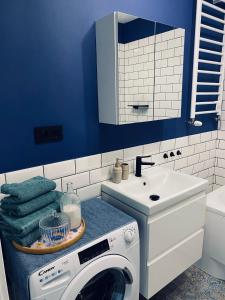 a blue bathroom with a washing machine and a sink at Apartament u Liska in Rumia +15 photos