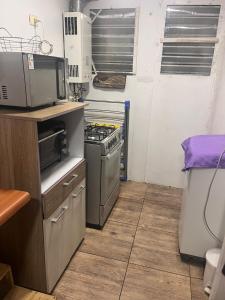 a small kitchen with a stove and a microwave at Playa de Dichato in Dichato