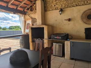a kitchen with a stove and a table with a chair at Au Marron in Seissan