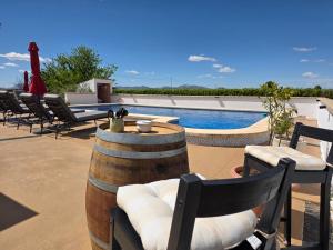 a patio with chairs and a swimming pool with a table and barrels at Casa de las Murallas, Bed&Breakfast in Yecla