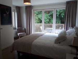a bedroom with a bed and a large window at Chalet Du Mont in Ruien