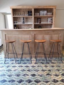 a bar with three stools in front of a counter at Chalet Du Mont in Ruien