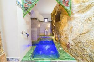 a bathroom with a blue tub in a room with a stone wall at Casa de la Robledo in Peñaflor