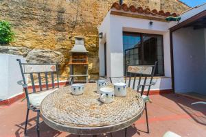 a table with cups and chairs on a patio at Casa de la Robledo in Peñaflor
