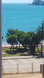 a tennis court with trees and the ocean in the background at Playa de Dichato in Dichato +6 photos