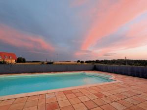 a swimming pool with a rainbow in the sky at Au Marron in Seissan