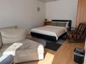 a room with two beds and a couch and a chair at your accomodation in Aachen in Aachen
