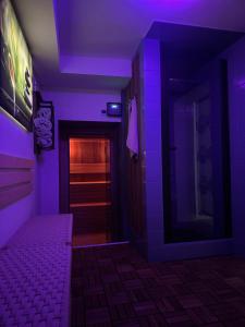 a purple room with a bed and a hallway at CHATA u BABULŮ in Morávka