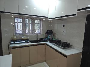 a kitchen with white cabinets and a stove top oven at House 27 in Idu +13 photos