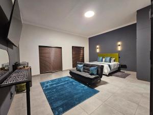 a large bedroom with a bed and a couch at Namloom Guesthouse in Pretoria
