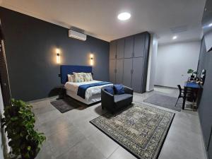 a bedroom with a bed and a chair at Namloom Guesthouse in Pretoria