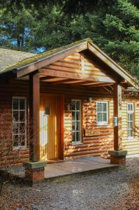 a small log cabin with a porch and a door at Grand Fir Lodge - The Hollies Retreats in Tarporley