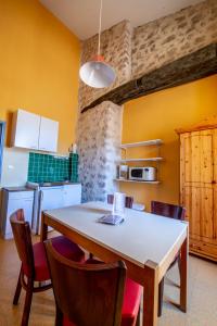 a kitchen with a table and chairs in a room at Le Cloître des Dominicains in Buis-les-Baronnies