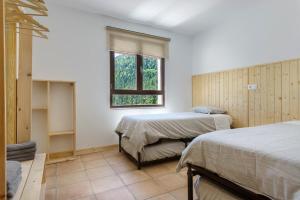 a bedroom with two beds and a window at Camping Selva de Oza in Hecho