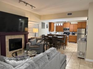 a living room with a couch and a table and a kitchen at Lakeshore Villa Estates in Osoyoos