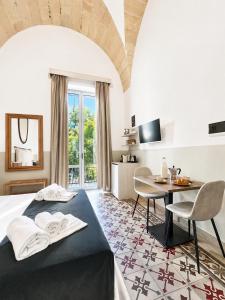 a hotel room with a bed and a table at Eccelsoleccese Boutique B&B - steps from the Historic Center in Lecce