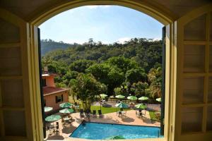 a view of a pool from a window of a resort at Hotel fazenda do Cedro in Areal