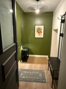 a hallway with green walls and a door with a rug at Independent studio on a property in Cognac