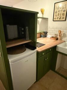 a kitchen with green cabinets and a microwave at Independent studio on a property in Cognac