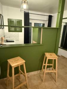 two wooden stools in a room with a green wall at Independent studio on a property in Cognac