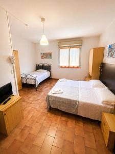 a bedroom with a large bed and a television at Hotel Nazionale in Milano Marittima