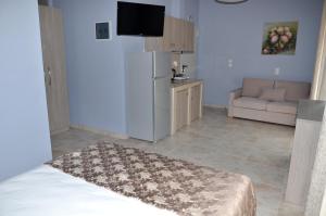 a living room with a refrigerator and a couch at Troia Resort Luxury Studios in Asprovalta
