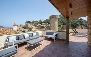a patio with couches and chairs on a roof at Luxury Rocamar – Primera Línea y Terraza in Tossa de Mar