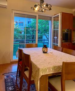 a dining room with a table and a large window at Cozy Home in Peje