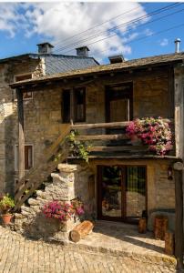 a stone house with flowers in front of it at Casa do Tio Zé Montesinho in Montezinho