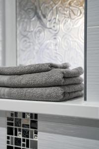 a pile of towels on a shelf in a bathroom at The Apartment at Charles Road in Frome +13 photos