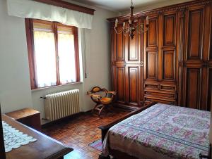 a bedroom with a bed and a chair and windows at Appartamento Ginetto in Corsalone