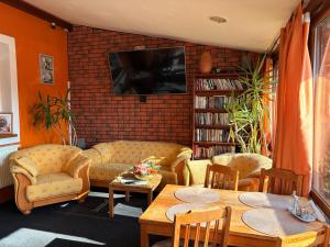 a living room with couches and tables and a tv at Dovolenkový dom Ela pets friendly in Poprad