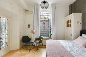a bedroom with a bed and a chair and a window at The Velvet Suite Alkmaar in Alkmaar