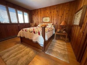 a bedroom with a bed and a table with a lamp at Stack's Back Bay Retreat in Minocqua +25 photos