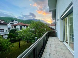 a balcony of a building with a sunset in the background at Cozy Home in Peje