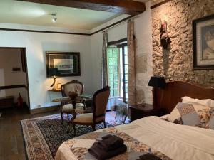 a bedroom with a bed and a table and chairs at Moulin de Bapaumes in Nérac