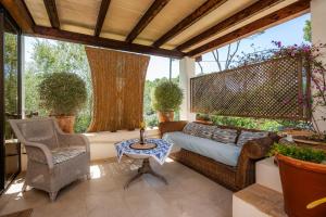 a porch with a bed and a chair and a table at Cel Pins in Portopetro