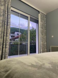 a bedroom with a large window with a view at Cozy Home in Peje