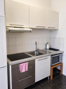 a kitchen with a sink and a microwave at Appartement bien-être in Liège