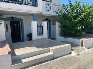 a white house with stairs leading to a door at studios costareli in Vrachonisída Diapóri