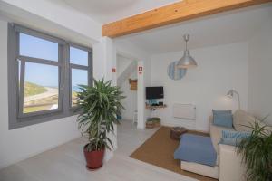 a living room with a couch and a window at Agapito's Houses in Praia de Odeceixe