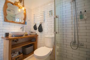 a bathroom with a toilet and a sink and a shower at Agapito's Houses in Praia de Odeceixe +61 photos
